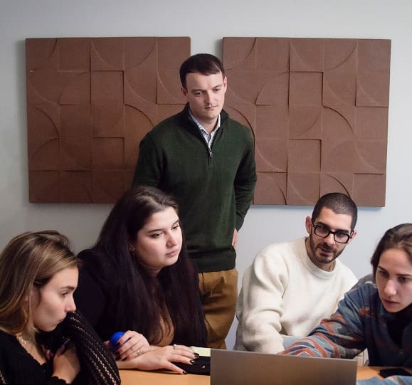Tom Salley coaching a team during a strategy session with wall art in the background